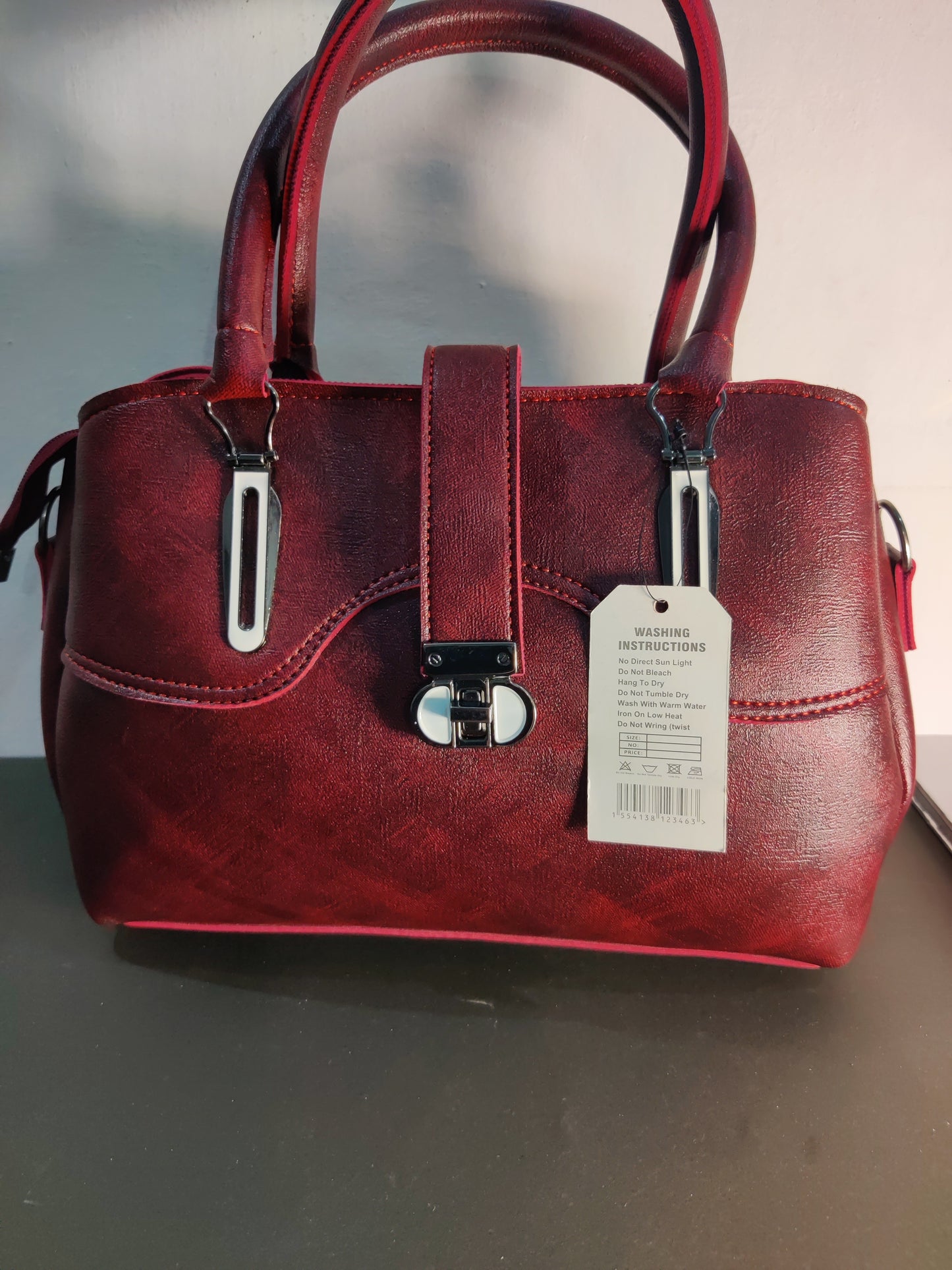 Maroon Women's Handbag, Often Categorized as a Top-handle Satchel or Formal Handbag.